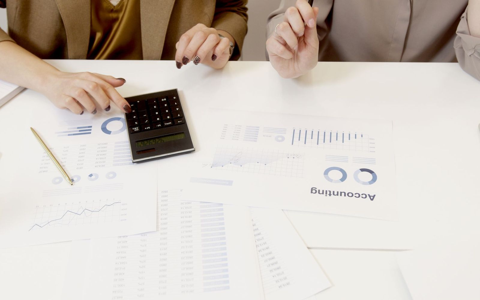 A desk with company accounts, a calculator and a pension statement