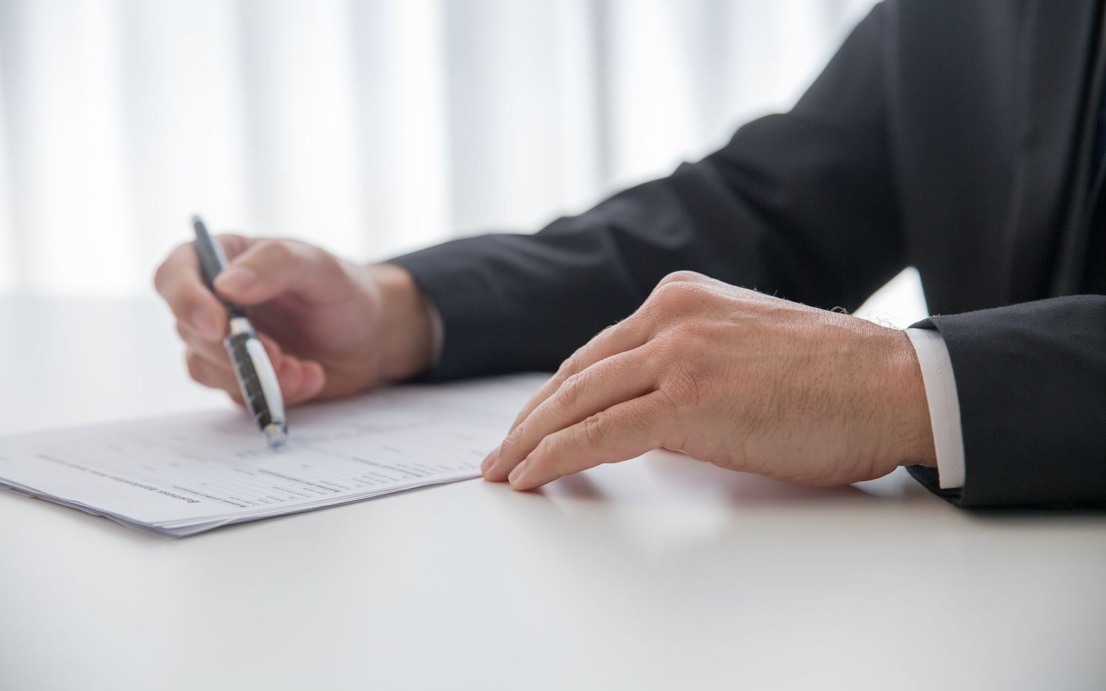 Two people going through paperwork across a desk