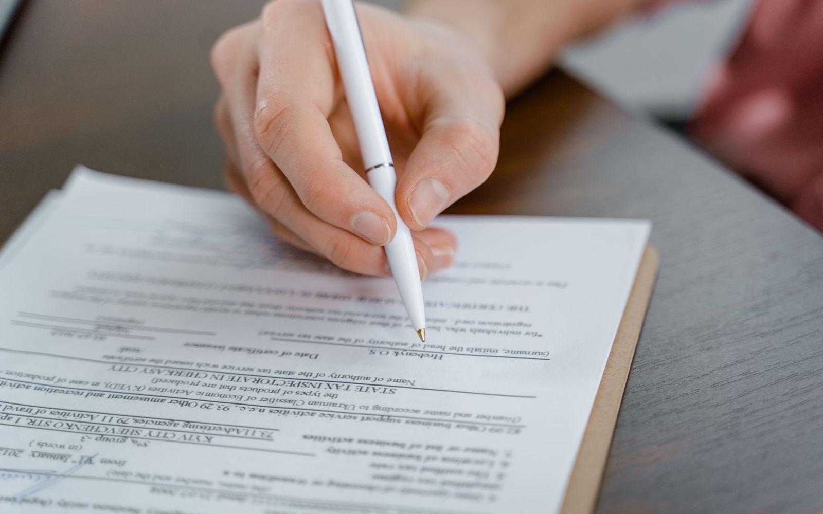 A close-up of someone holding printed paperwork