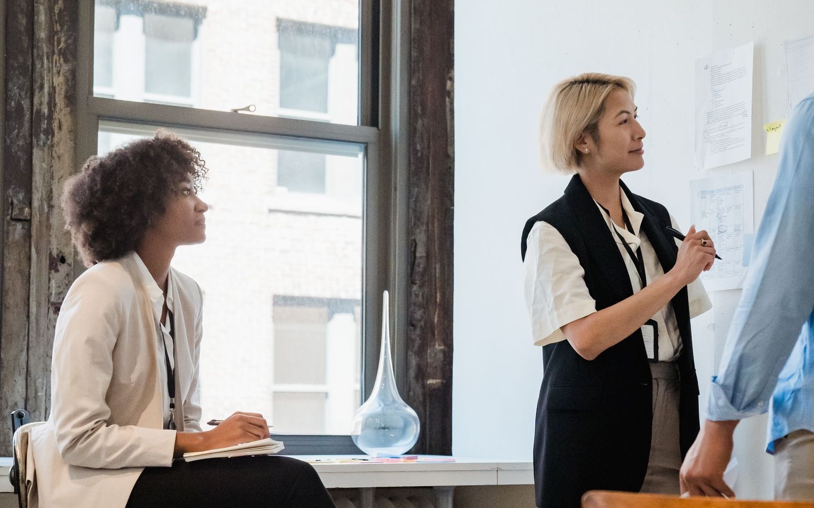 Two people talking across a table in a workplace