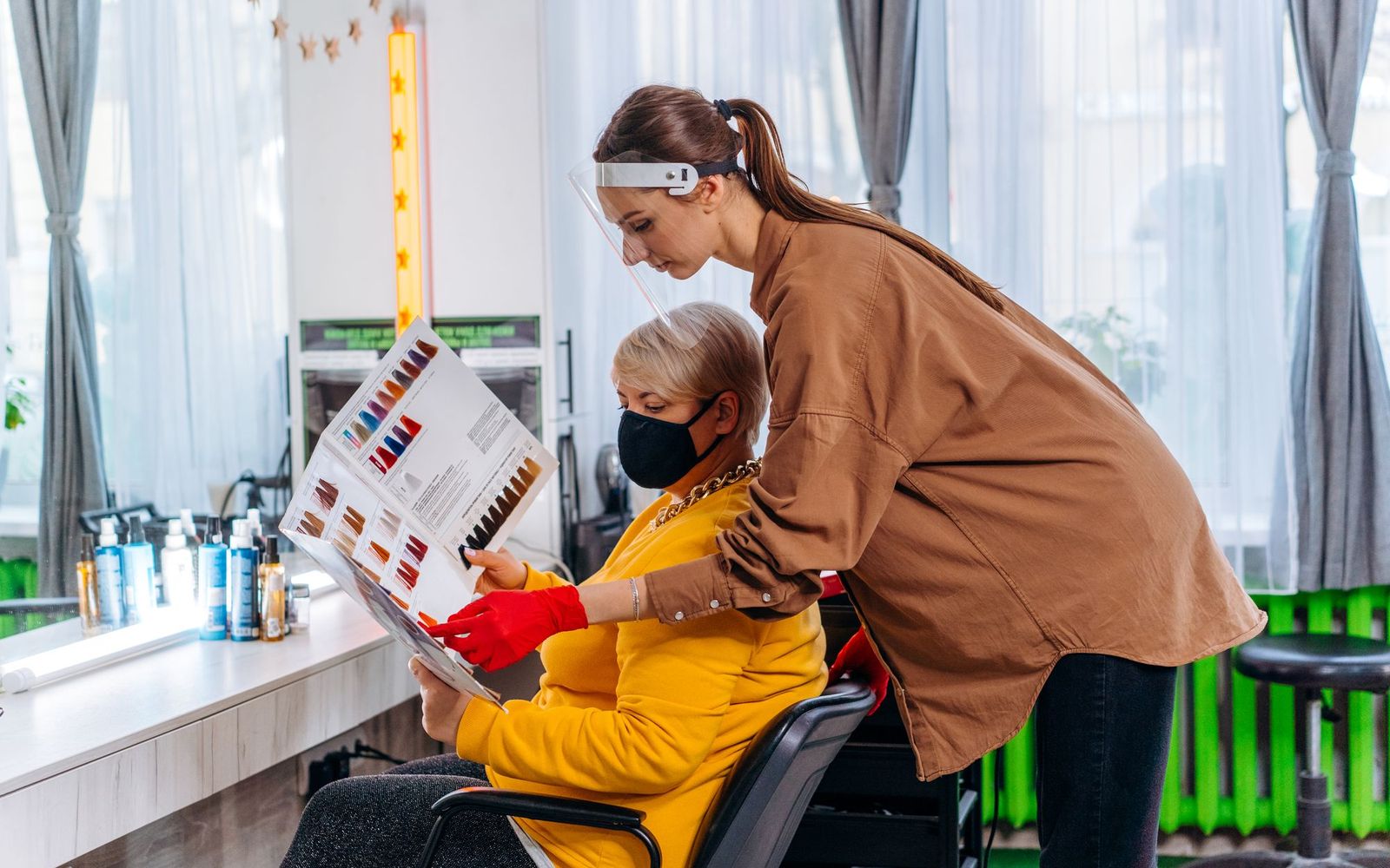 Two people talking across a desk in a small office