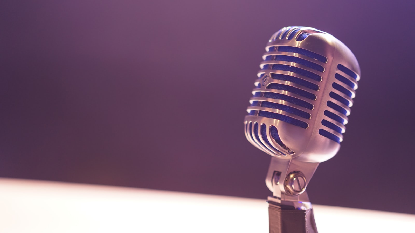 A studio condenser microphone against a dark background